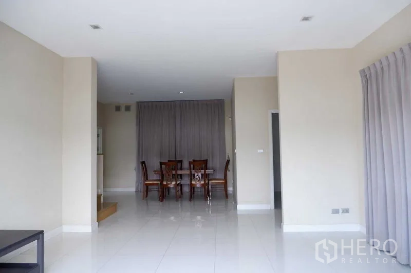 独立式住宅 出售在Lat Krabang, Bangkok - 采光充足的客餐厅一体区，白色亮面地砖与大窗帘