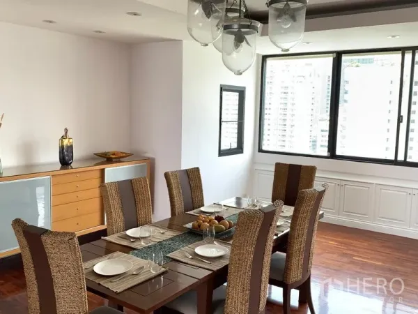 Condominium for sale in Khlong Toei, Bangkok - Windowed dining room with city views, pendant lighting and a sideboard cabinet.
