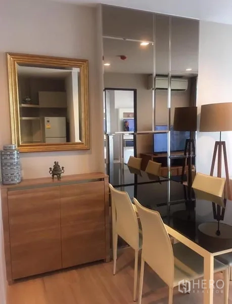 公寓 出租在Sathon, Bangkok - 用餐角落，镜面墙、黑玻餐桌、边柜与现代落地灯