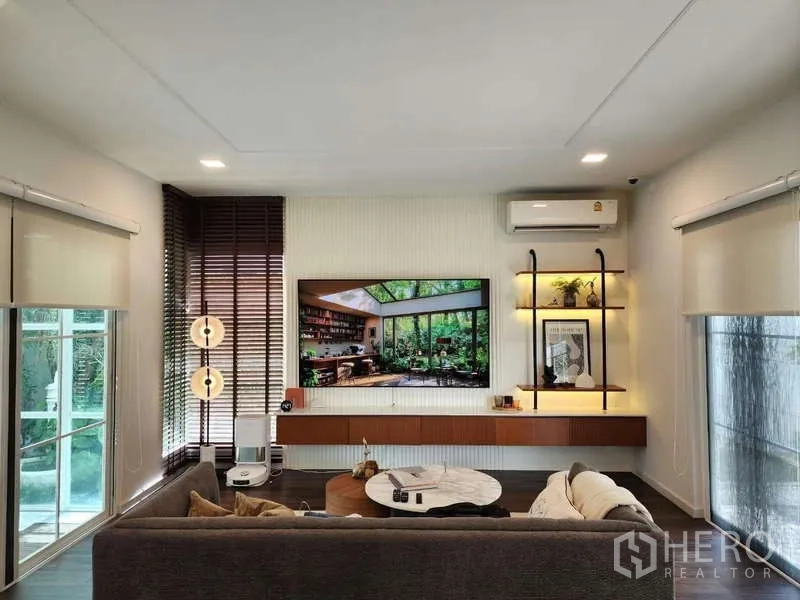 Detached House for rent or sale in Bang Phli, Samut Prakan - TV feature wall with floating console and open shelves in the lounge.