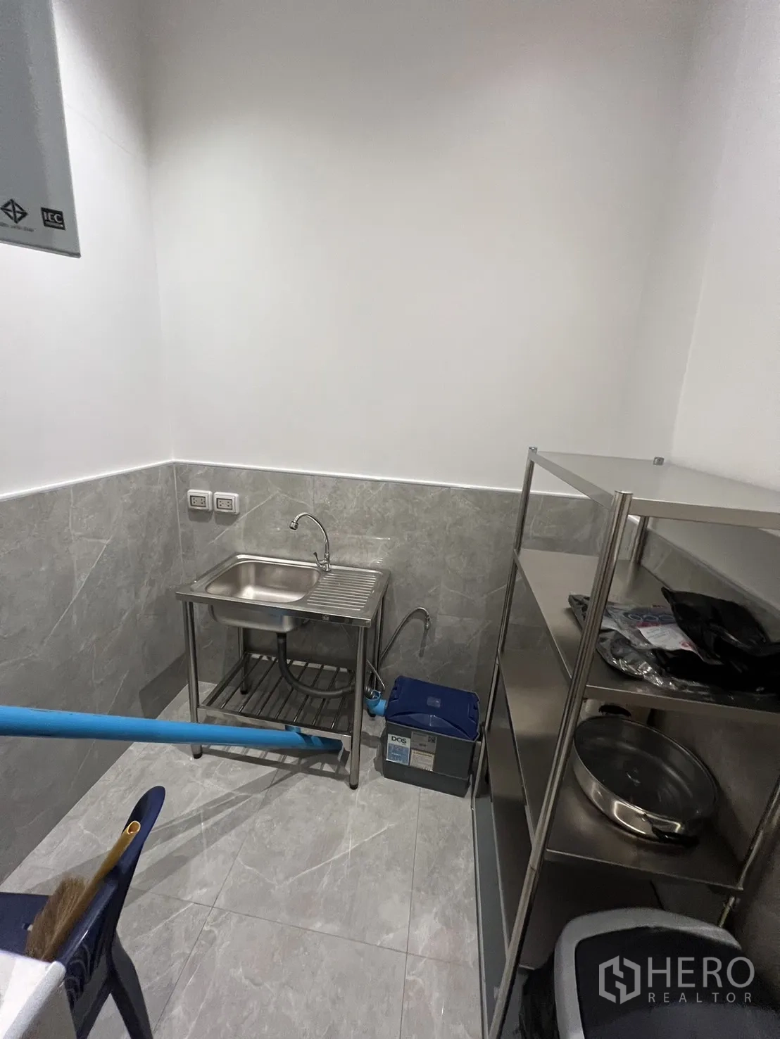 Retail Space for rent - Stainless-steel pantry with sink, shelves and exposed utility piping.