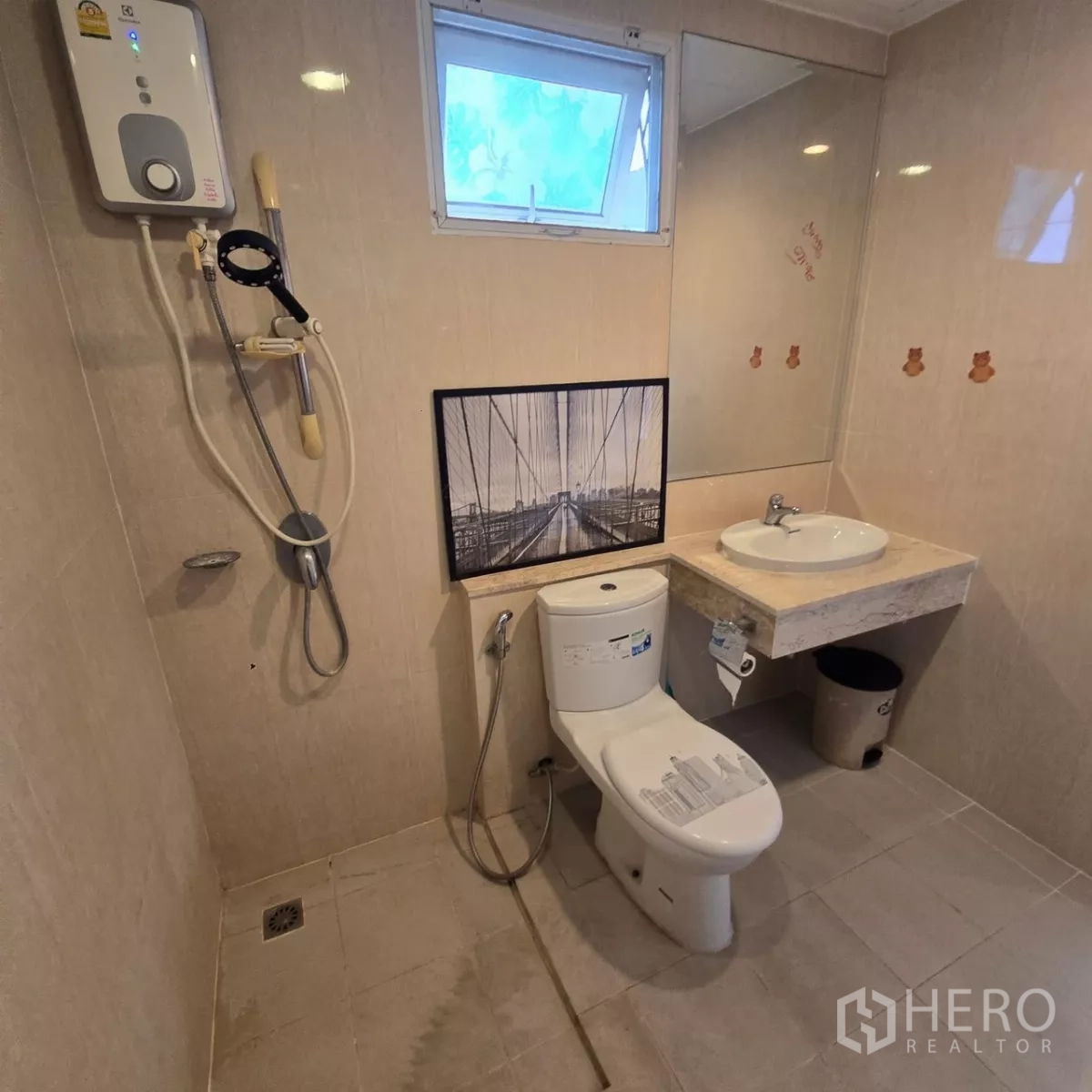 Detached House for rent in Mueang Pathum Thani, Pathum Thani - Clean tiled bathroom with handheld bidet and framed wall art.