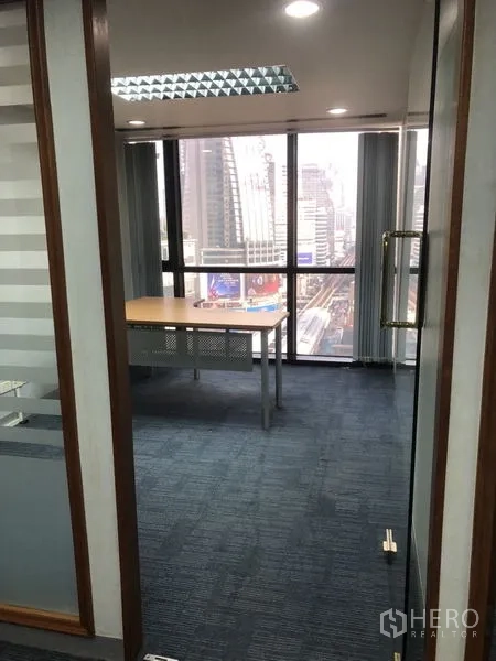 Office Space for rent - Cluster of corner workstations with blue panels in the open office area.