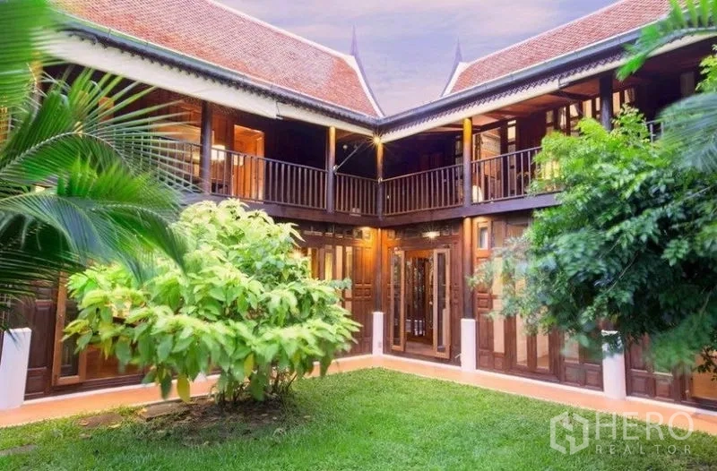 Detached House for rent in Bang Na, Bangkok - Courtyard of traditional Thai house with grassy lawn and upper balconies.