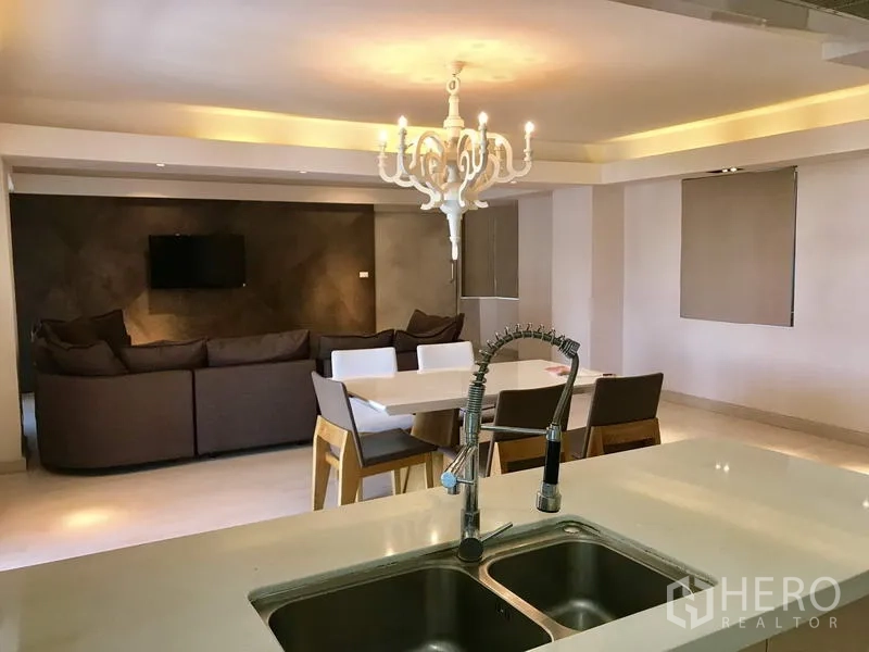 Condominium for rent in Watthana, Bangkok - Modern open kitchen with double sink overlooking the dining table and lounge.