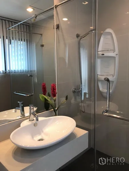 Condominium for rent or sale in Sathon, Bangkok - Modern bathroom with glass-enclosed shower, vessel sink and chrome fixtures.