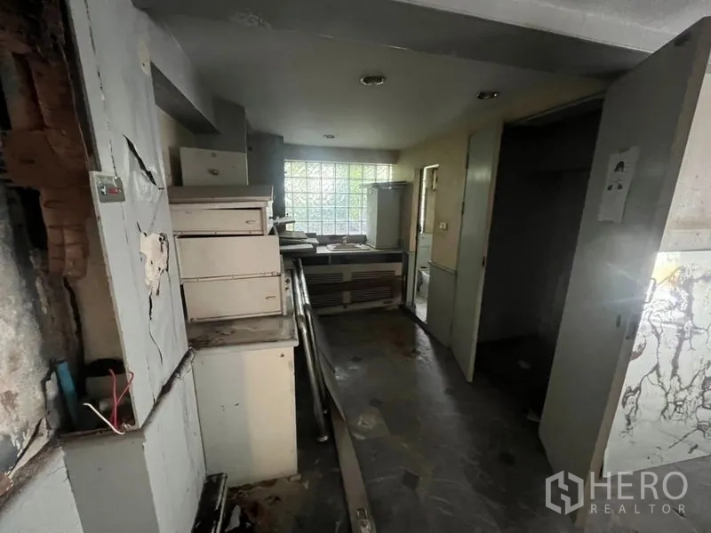 Retail Space for rent in Watthana, Bangkok - Back-of-house service area with cabinets and a glass-block window, ready for renovation.