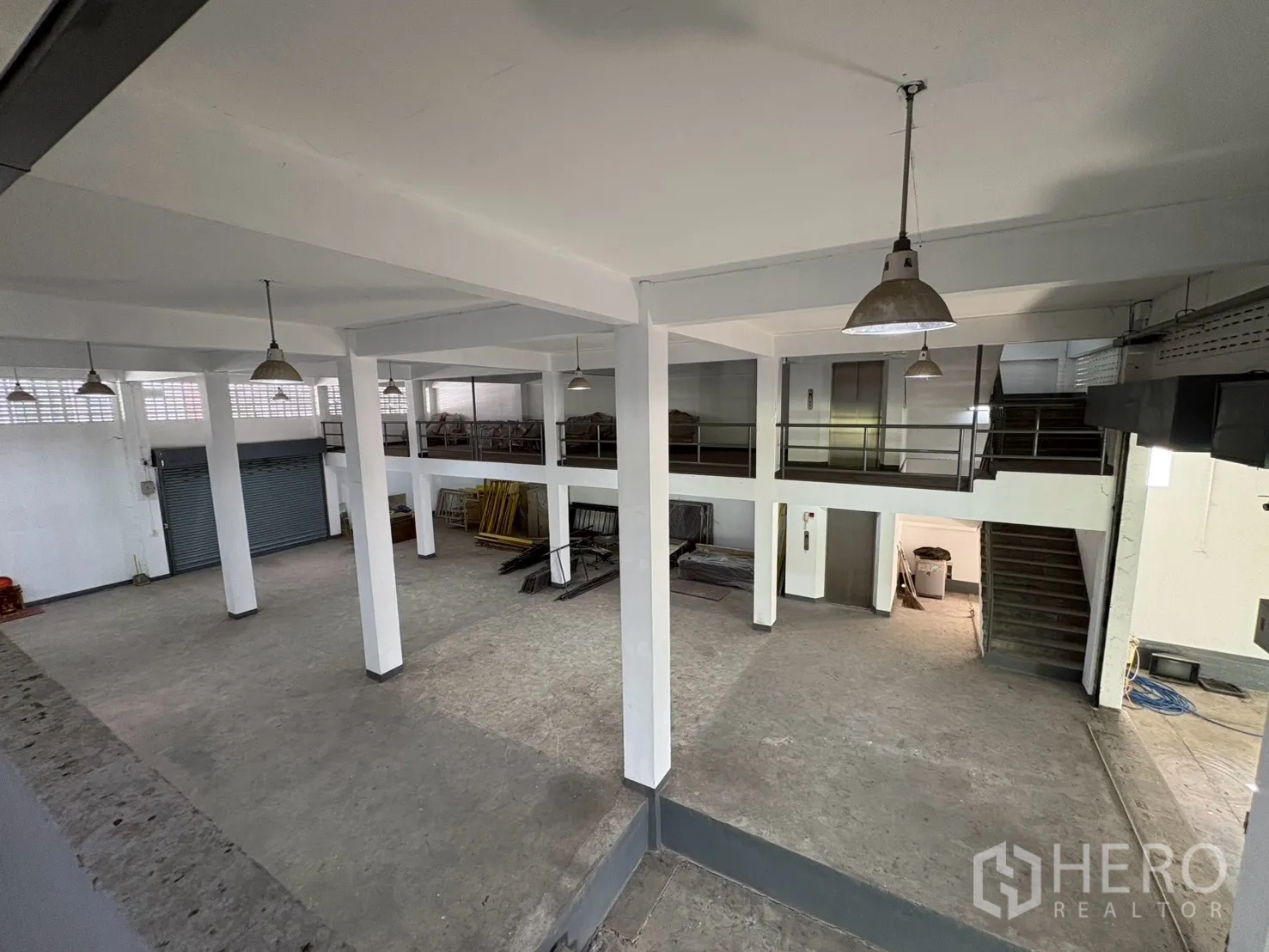 Warehouse for rent in Bang Na, Bangkok - Overlook of mezzanine platforms, stair access, and roller shutters.