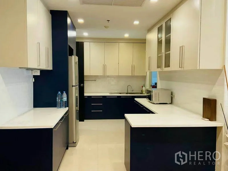 公寓 出租在Watthana, Bangkok - 完整厨房，储物柜充足，不锈钢冰箱与石材台面。