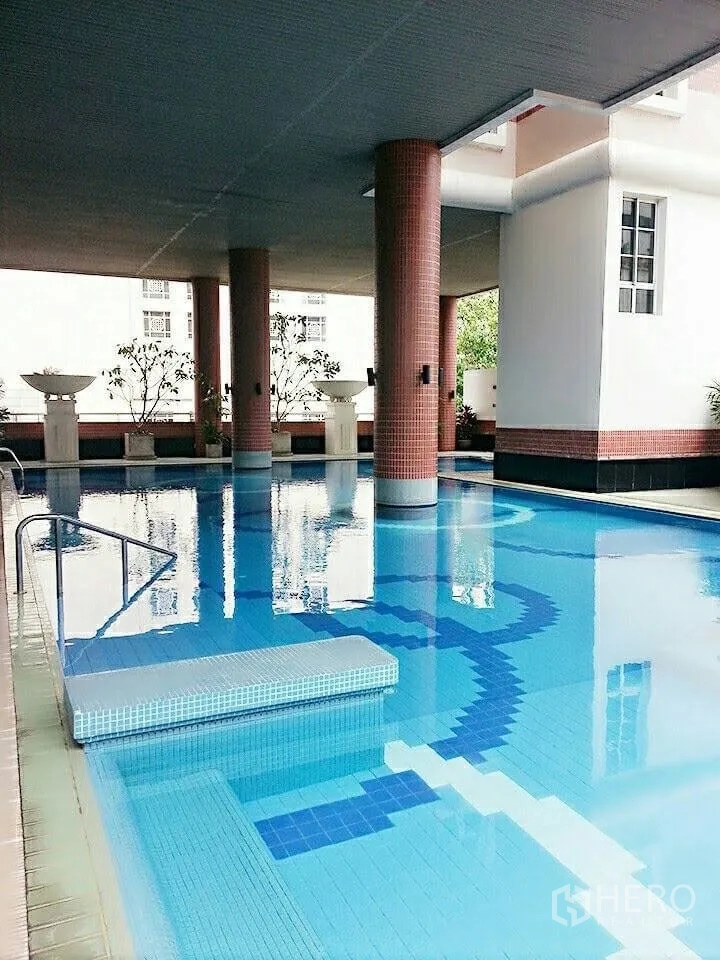 Condominium for rent in Khlong Toei, Bangkok - Condominium facilities with a covered swimming pool and patterned blue tiles.
