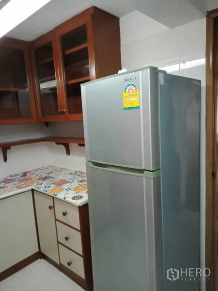 联排别墅 出租在Khlong Toei, Bangkok - 厨房角落，双门冰箱与木质柜体
