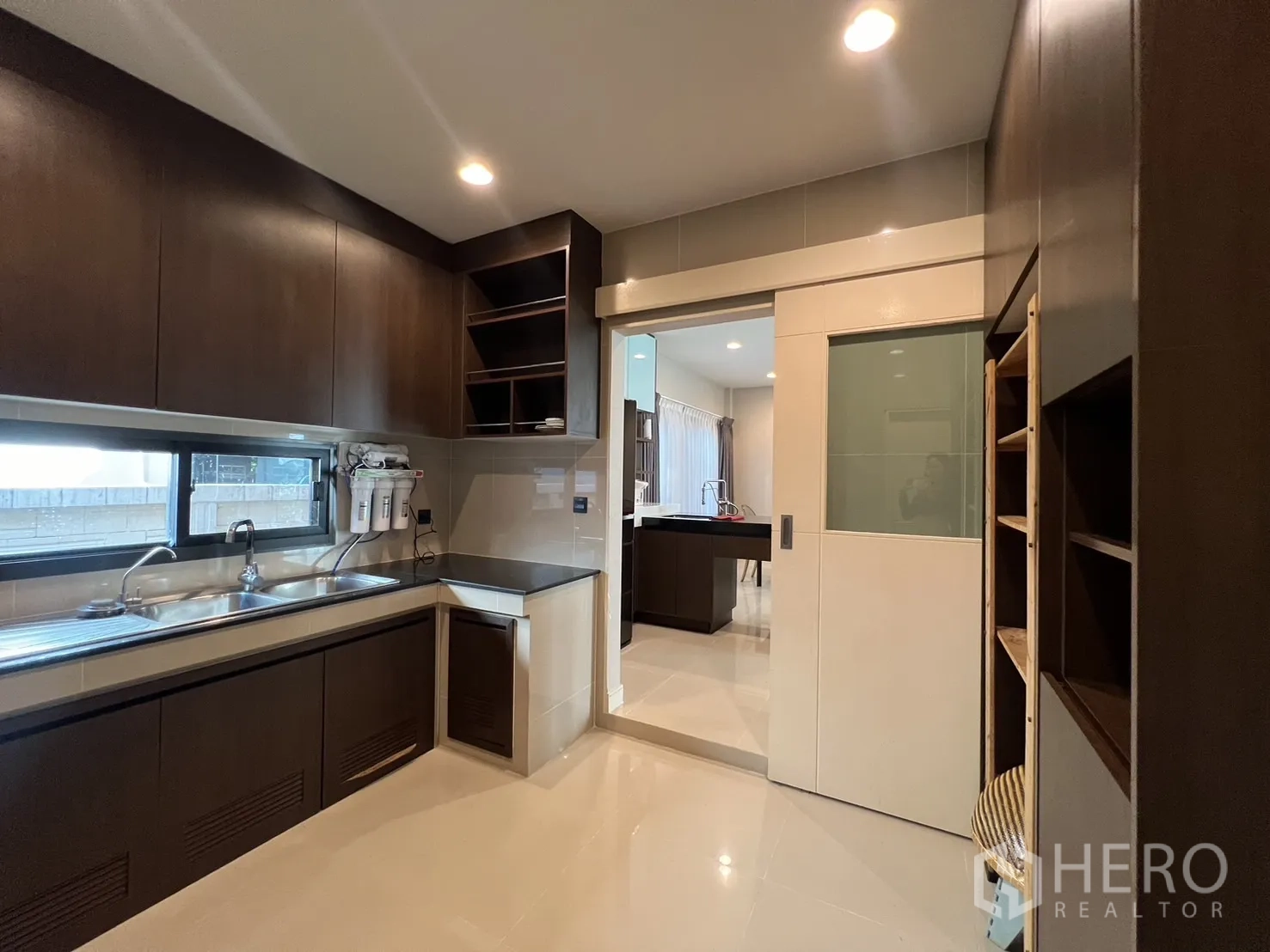 独立式住宅 出租或出售在Bang Kapi, Bangkok - 厨房长操作台、双水槽，推拉门通往餐厅。