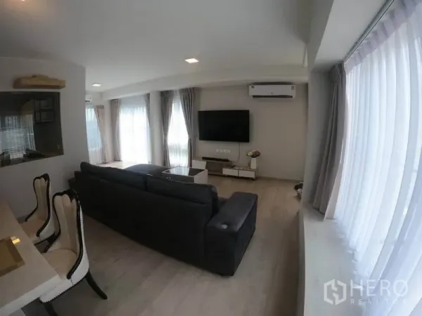 独立式住宅 出租在Prawet, Bangkok - 客厅多面窗帘与空调，电视背景墙设计。