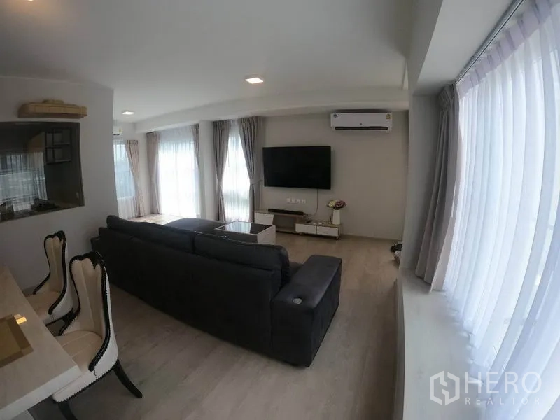独立式住宅 出租在Prawet, Bangkok - 客厅多面窗帘与空调，电视背景墙设计。
