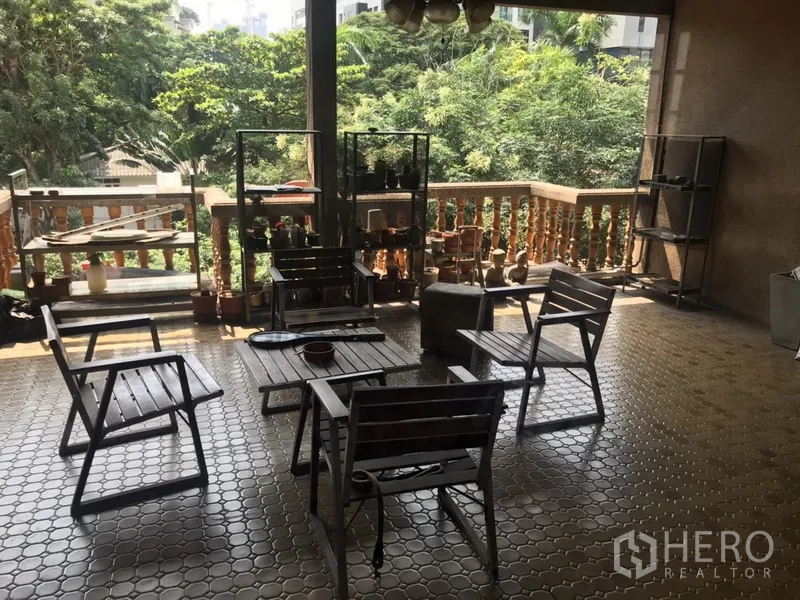 Home Office for rent in Khlong Toei, Bangkok - Covered terrace with tiled floor, wooden seating and leafy treetop views.