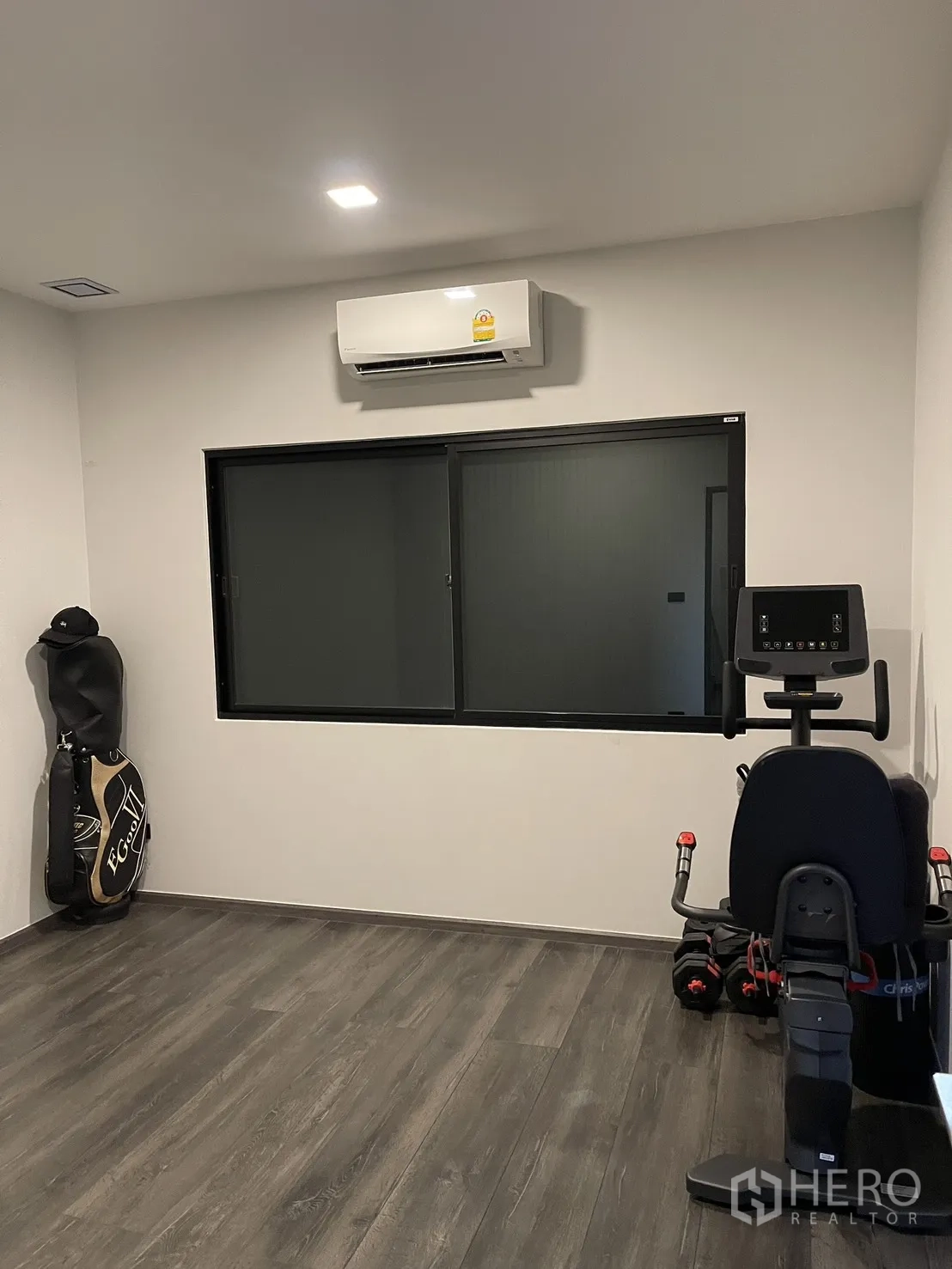 Townhouse for sale in Bang Phli, Samut Prakan - Air-conditioned flex room with exercise bike, window, and wood-look flooring.