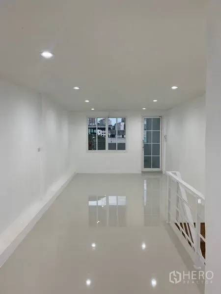 Townhouse for sale in Yan Nawa, Bangkok - Bright open-plan living area with glossy floors and recessed lighting.
