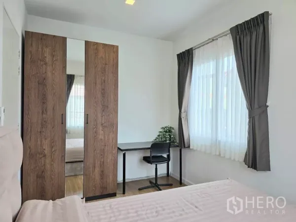 บ้าน ให้เช่าในSamut Prakan - ห้องนอนรองพร้อมตู้เสื้อผ้า โต๊ะทำงาน และหน้าต่างสองด้านมีผ้าม่าน
