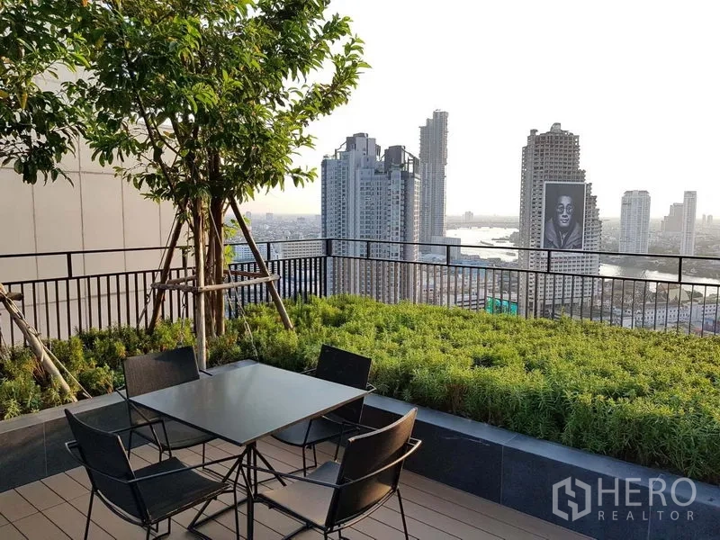 公寓 出售在Bang Rak, Bangkok - 屋顶花园露台，桌椅与城市天际线/河景。