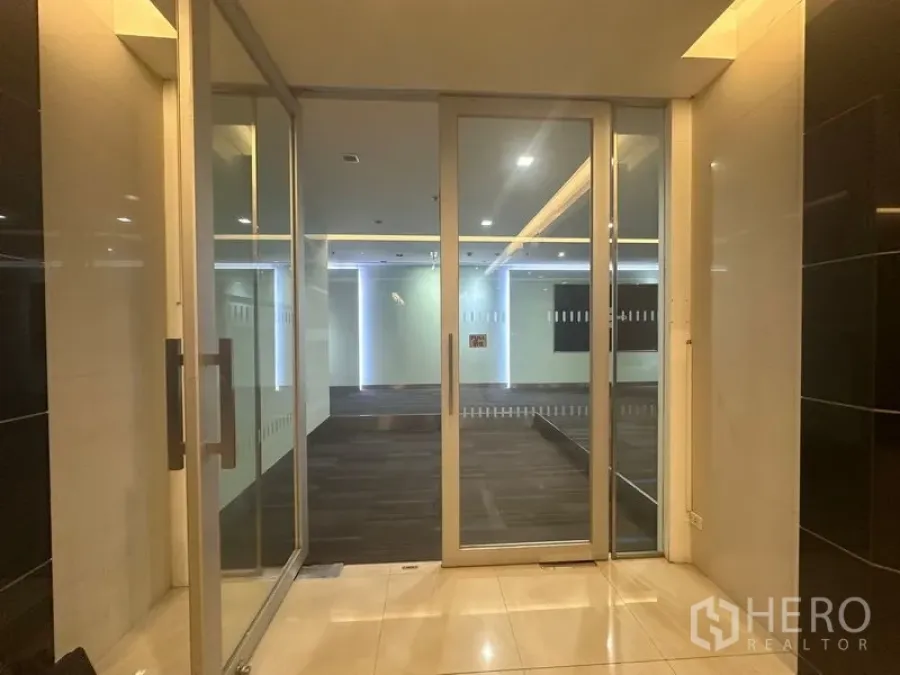 Office Space for rent in Khlong Toei, Bangkok - Glass entry doors leading to a carpeted reception area with feature lighting.