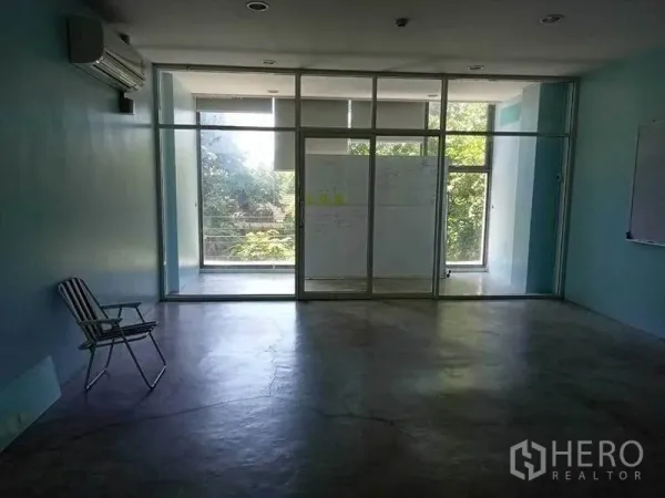 Office Space for rent in Khlong Toei, Bangkok - Open-plan office interior with polished concrete floor, floor-to-ceiling glass doors, air conditioning and leafy views.