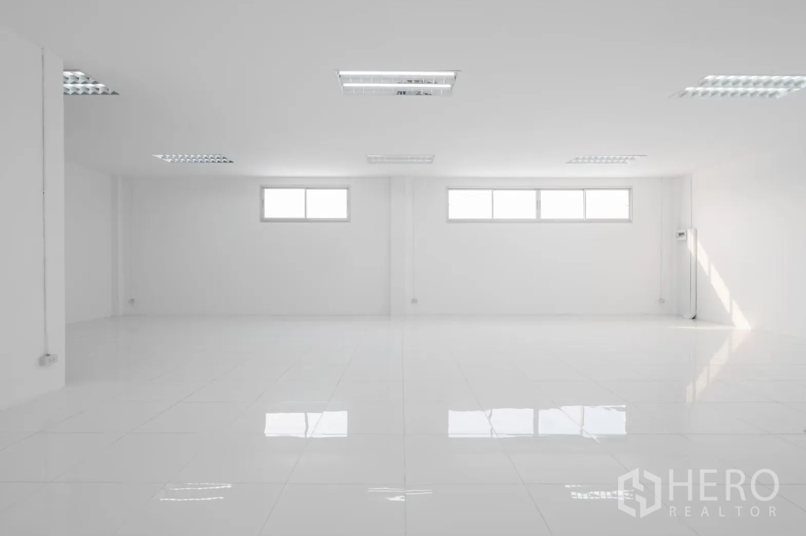 Factory for rent in Pathum Thani - Open white workspace with three horizontal windows and glossy tiles.