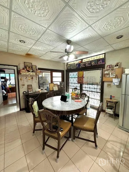 Detached House for sale in Yan Nawa, Bangkok - Family dining room with round marble table, ceiling fan and patterned ceiling.