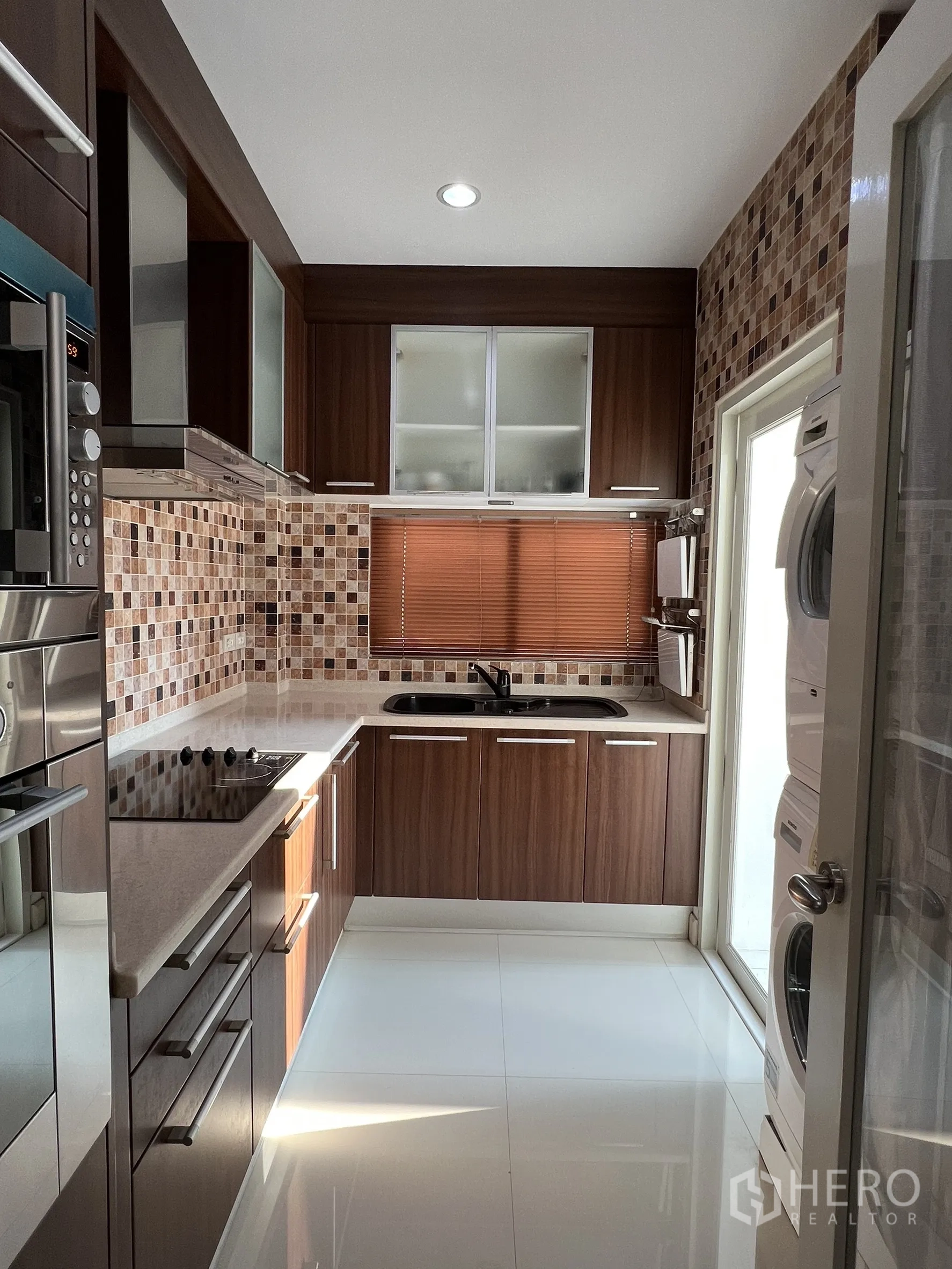 独立式住宅 出租或出售在Saphan Sung, Bangkok - 整体厨房，木纹橱柜、电磁炉、双槽水槽与马赛克墙。