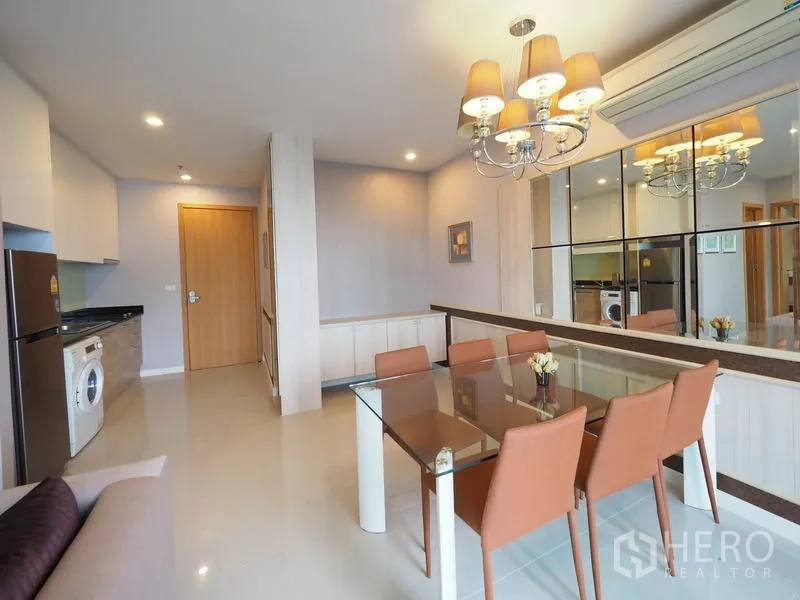 คอนโด ให้เช่าในRatchathewi, Bangkok - โซนทานอาหารโต๊ะกระจกพร้อมโคมไฟระย้า ข้างครัวขนาดกะทัดรัดมีตู้เย็นและเครื่องซักผ้า