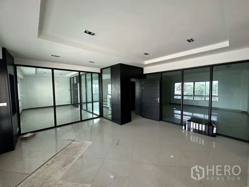 Factory for rent or sale in Bang Bua Thong, Nonthaburi - Clean tiled restroom with toilet, urinal, sink and natural light window.