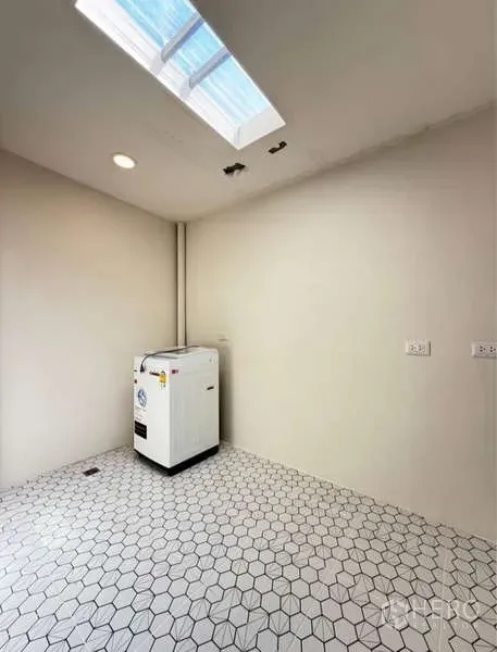 Townhouse for rent in Bang Phli, Samut Prakan - Bright laundry or utility room with hexagon tile floor, skylight and washing machine.