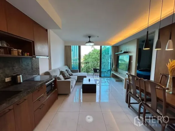 公寓 出租在Watthana, Bangkok - 开放式客厅，带厨房、沙发、餐桌和面向绿景的阳台