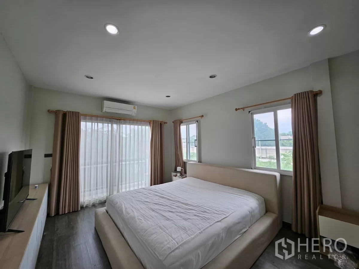 Detached House for rent in Khlong Toei, Bangkok - Primary bedroom with king bed, balcony sliding doors, two side windows and air conditioning.