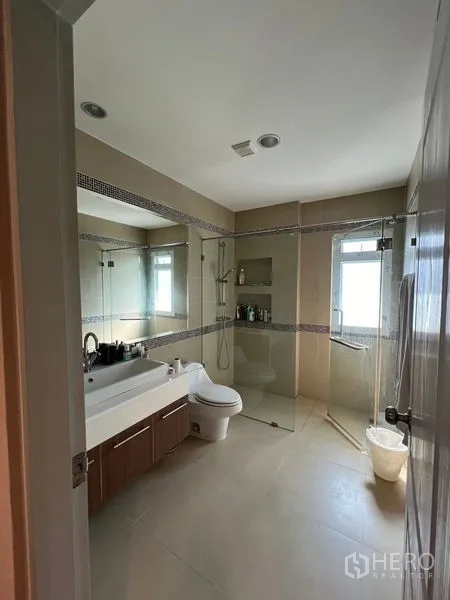 Detached House for rent or sale in Saphan Sung, Bangkok - Bright bathroom with glass shower enclosure, vanity and window.