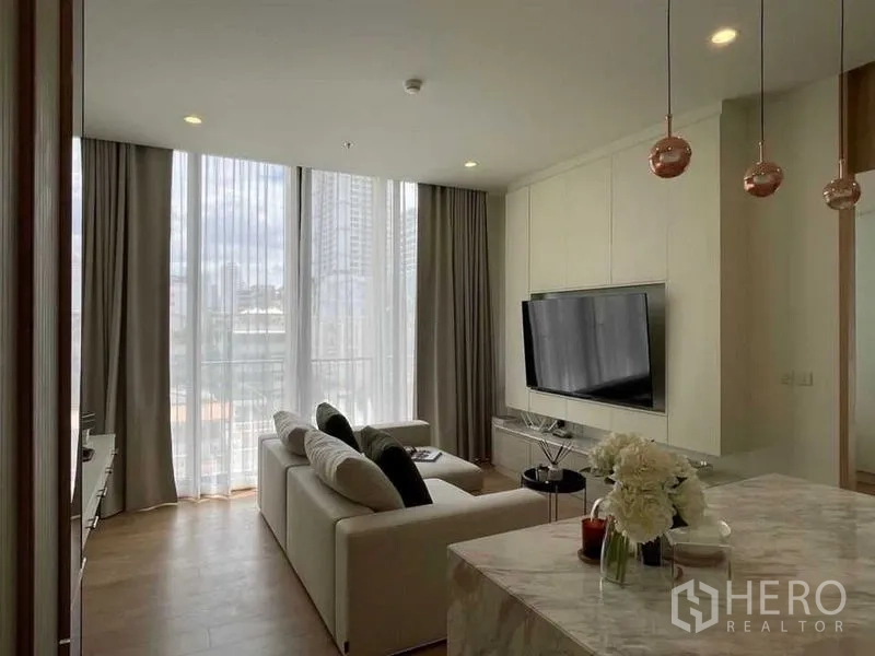 公寓 出售在Watthana, Bangkok - 开放式起居区，通高窗、电视墙与大理石中岛。