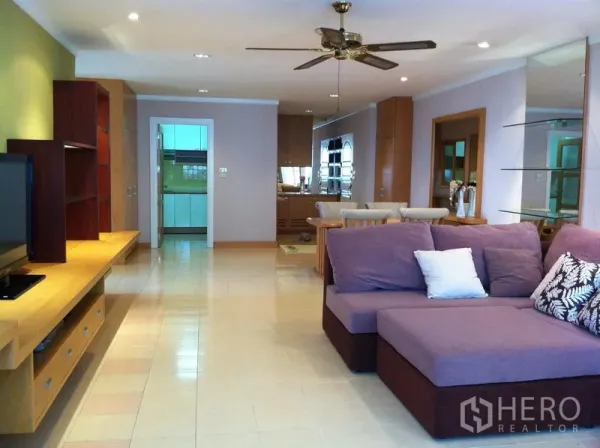 คอนโด ให้เช่าในWatthana, Bangkok - ห้องนั่งเล่นคอนโดสุขุมวิท 39 พื้นที่กว้าง โซฟาม่วงรูปตัว L ตู้ทีวีบิวท์อิน พัดลมเพดาน มองไปยังโซนทานอาหารและครัวปิด