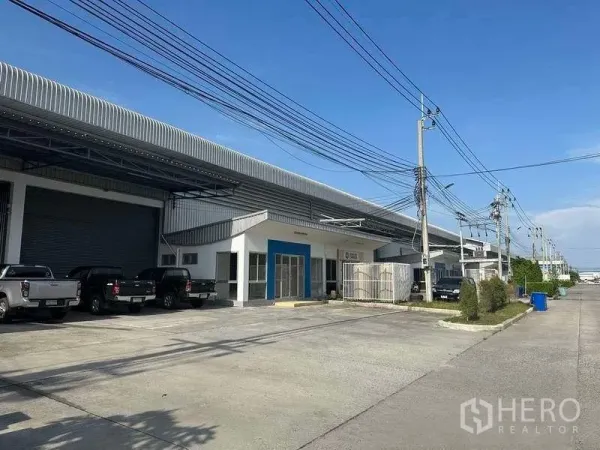 工厂 出租在Bang Sao Thong, Samut Prakan - 工业园内一排厂房，宽阔道路与停车位。
