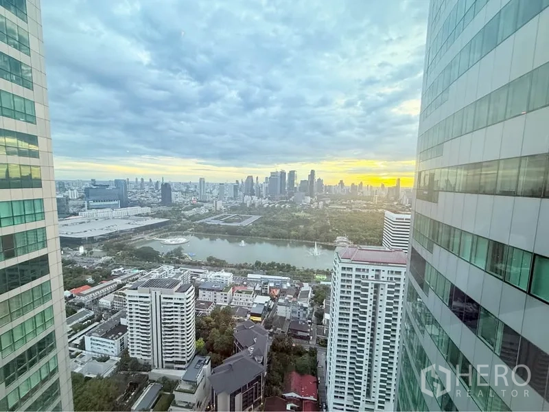คอนโด ให้เช่าหรือขายในKhlong Toei, Bangkok - วิวชั้นสูง เห็นสวนสาธารณะที่มีทะเลสาบและสกายไลน์ยามเย็นคั่นระหว่างตึกสูง