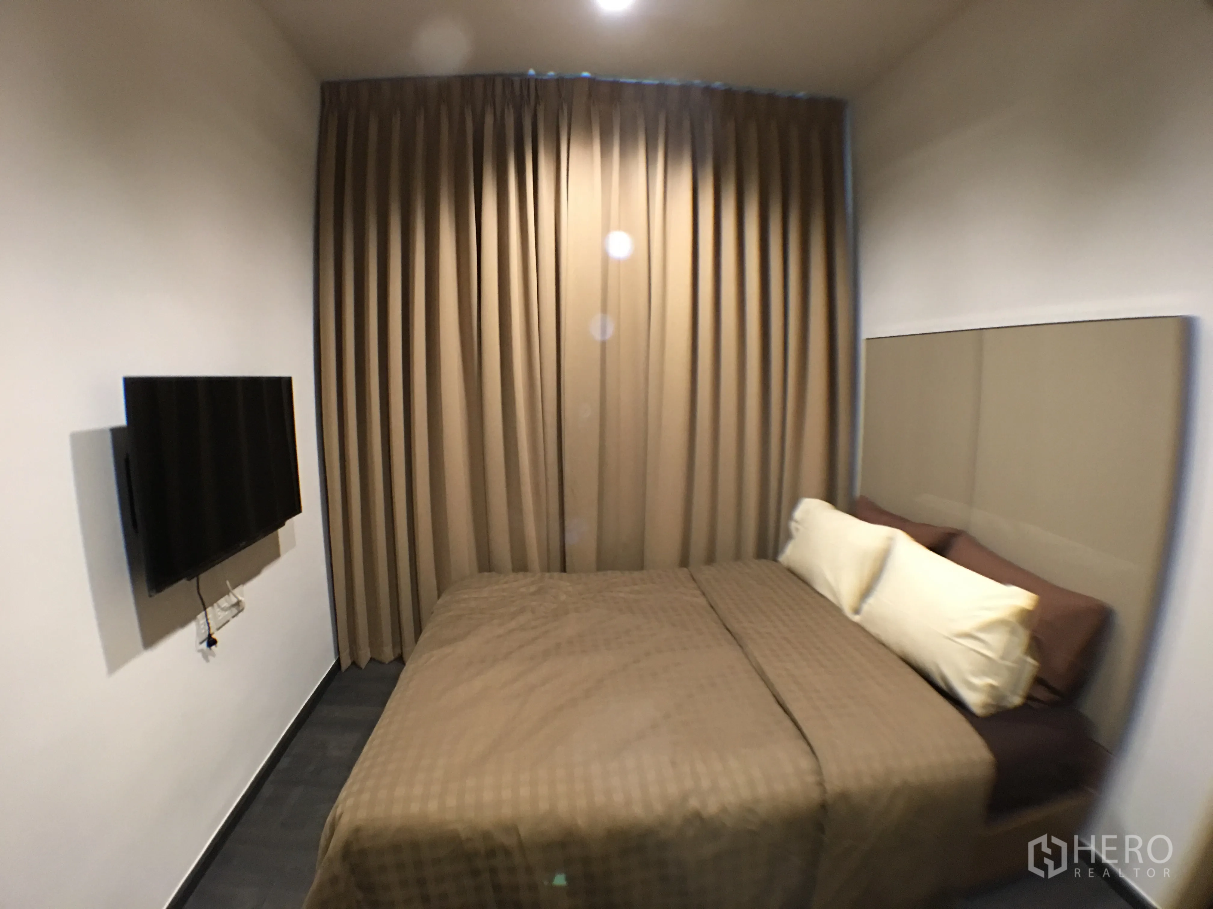 公寓 出租在Watthana, Bangkok - 卧室角度，壁挂电视、落地遮光窗帘与整洁的双人床。