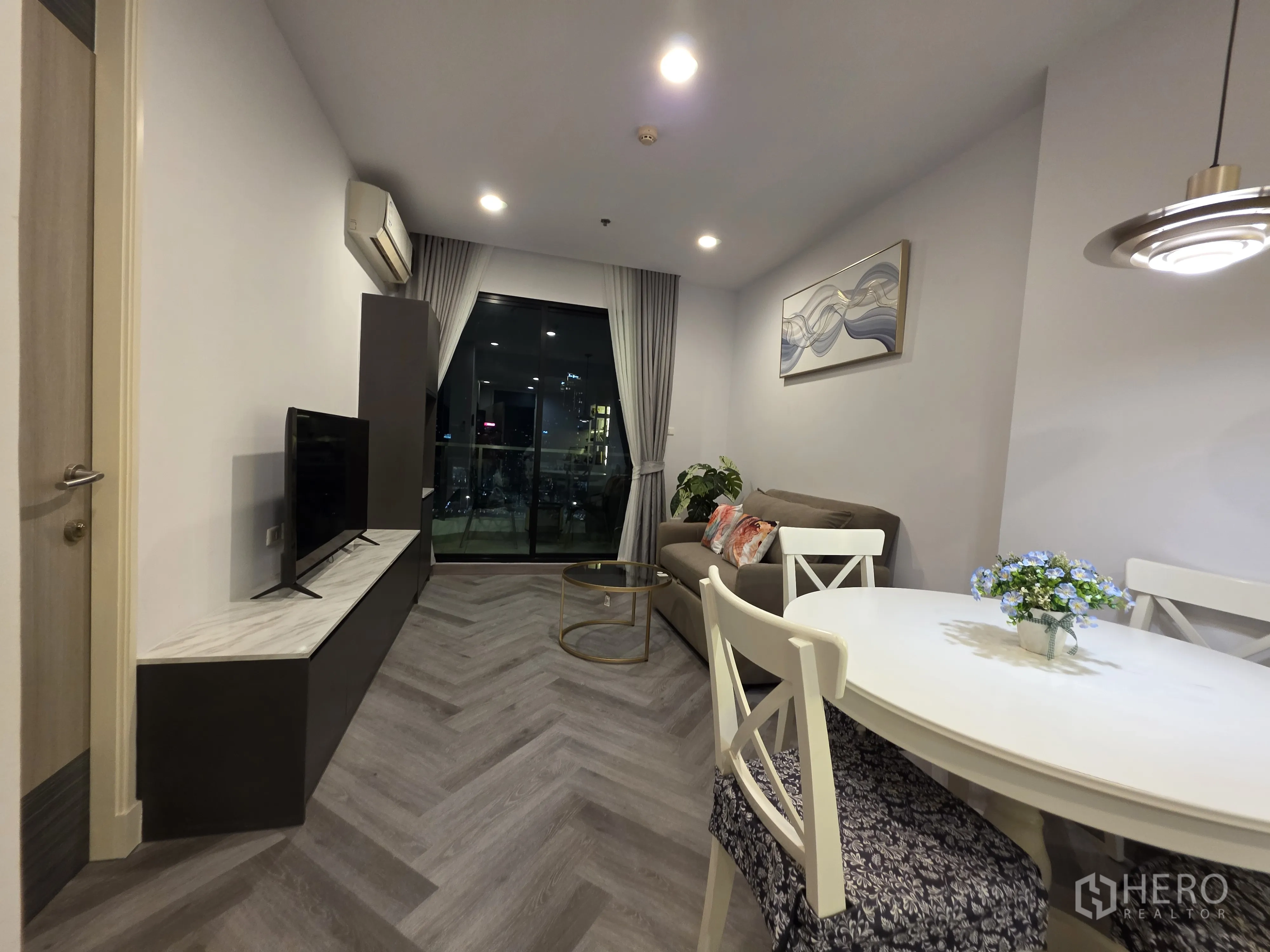 公寓 for rent in Bang Kapi, Bangkok - 客餐厅一体，配电视、圆形餐桌与阳台连通。