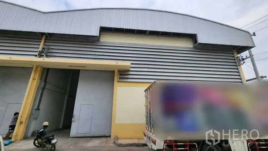 คลังสินค้า ให้เช่าในBan Phaeo, Samut Sakhon - ด้านหน้าโกดัง ประตูม้วนสูง ผนังเมทัลชีท พร้อมลานโหลดใกล้ถนนเอกชัย