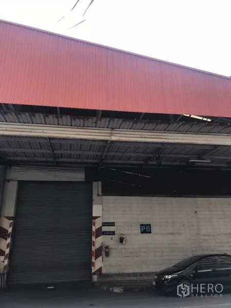 货栈 出租在Mueang Samut Prakan, Samut Prakan - 仓库外观，红色金属屋檐和大型卷闸门