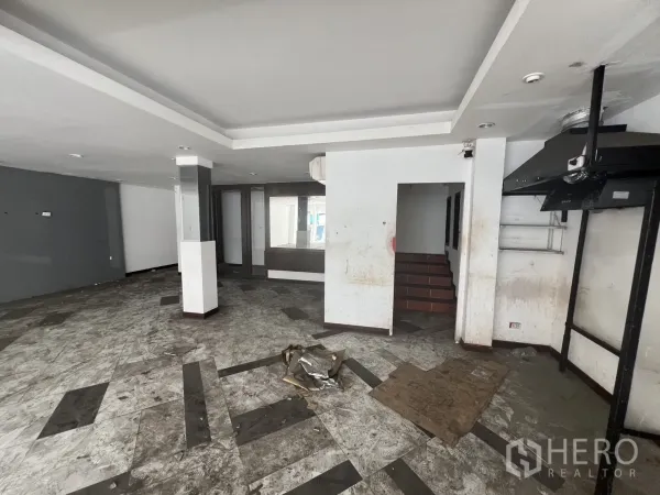 Retail Space for rent in Khlong Toei, Bangkok - Ground-floor shop interior showing tiled flooring, staircase and ventilation hood.