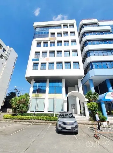 办公空间 出租在Bang Na, Bangkok - 邦那多层办公楼外观，前方设有停车位与绿化入口。