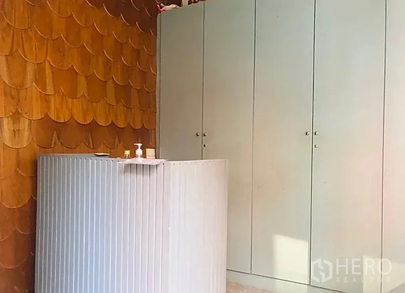 Retail Space for rent in Khlong Toei, Bangkok - Compact reception counter with wood feature wall and tall storage cabinets.