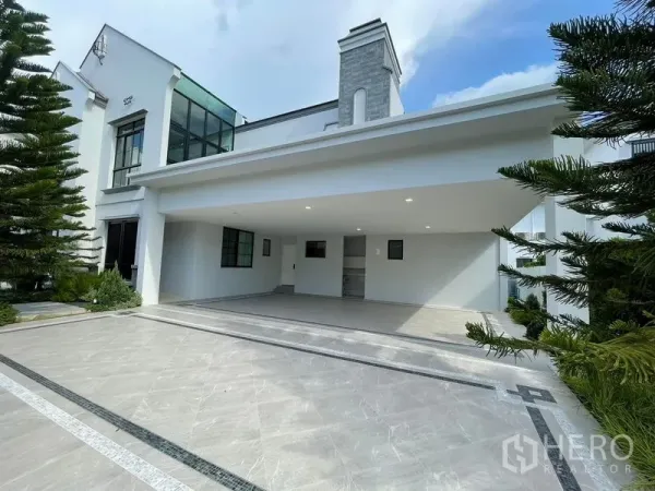 独立式住宅 出租或出售在Saphan Sung, Bangkok - 曼谷Saphan Sung现代白色独栋别墅外观，石材烟囱、景观车道与大面积有顶车库。