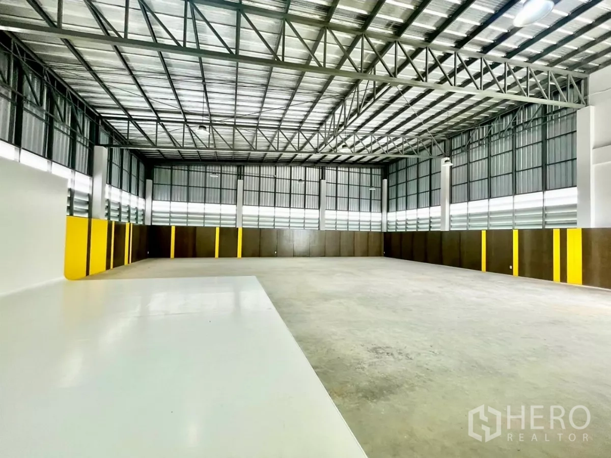 货栈 出售在Lam Luk Ka, Pathum Thani - 明亮仓库地面，设白色环氧区域与高窗引入自然光。