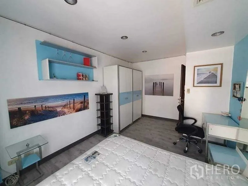 Townhouse for rent or sale in Bang Kho Laem, Bangkok - Alternate view of the blue bedroom showing shelves, double wardrobe and decor.