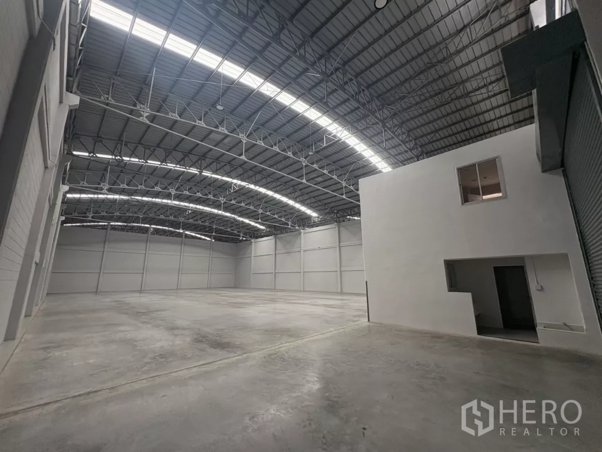 工厂 出租在Bang Phli, Samut Prakan - 仓库内景，带卷帘出入口与白色夹层办公室体块。