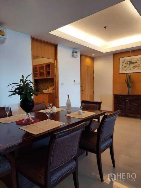 Apartment for rent - Dining room with wooden table and a view into the fitted kitchen.